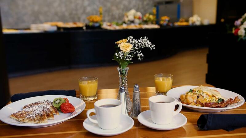 Coffee, orange juice and two plates of breakfast foods