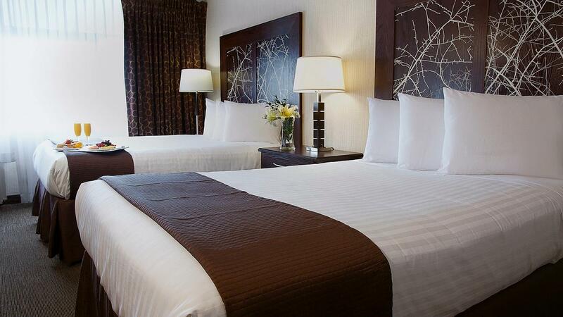 Two guest beds with flowers in a vase on the bedside table.
